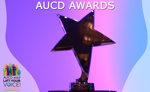 Photo of a gold star, presumably an award, on a purple background. Text: AUCD Awards. Includes AUCD 2017 conference logo in the bottom left corner.