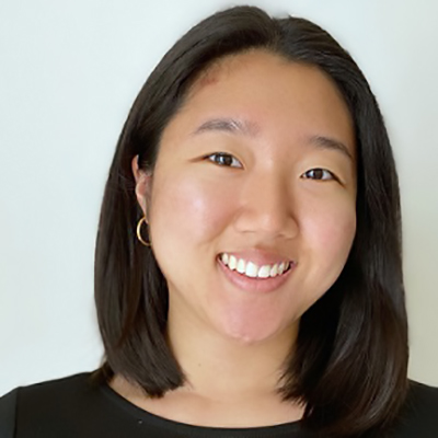 Image of Dana Kim, a smiling Asian-American woman with short black hair. She is wearing a black shirt in front of a white background. 