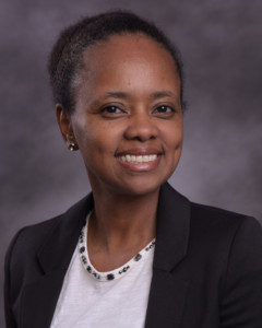 Image of Jenean Castillo, a Black woman with a white top and black blazer smiles at the camera.