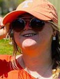 Molly, white yougn woman, smiling with orange Tennessee hat and orange top with a long blond braid