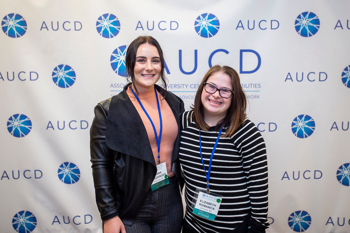 Image of 6 people smiling in front
of the AUCD banner, 2 hold awards.