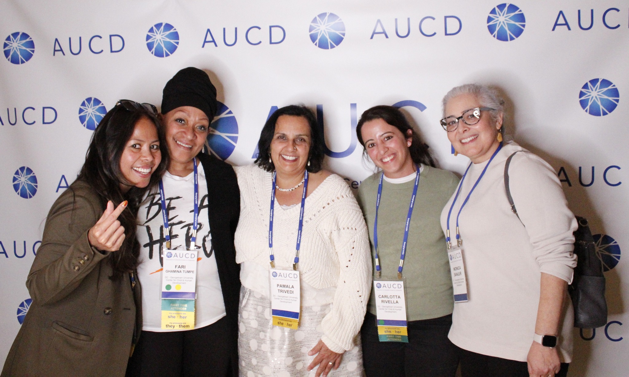 AUCD network members standing in front of AUCD banner smiling arm in arm