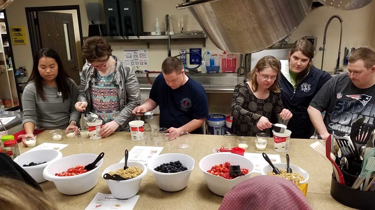 A group of individuals preparing food at a class. 