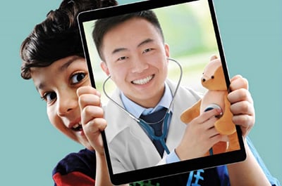 Image of a child holding a tablet showign a doctor smiling with a stethoscope to a toy bear