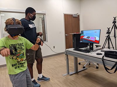 Image of a child using a virtual headset with therapist watching along side them. 