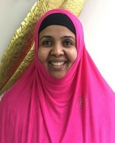 Image of a black woman wearing a pink hijab smiling at the camera.