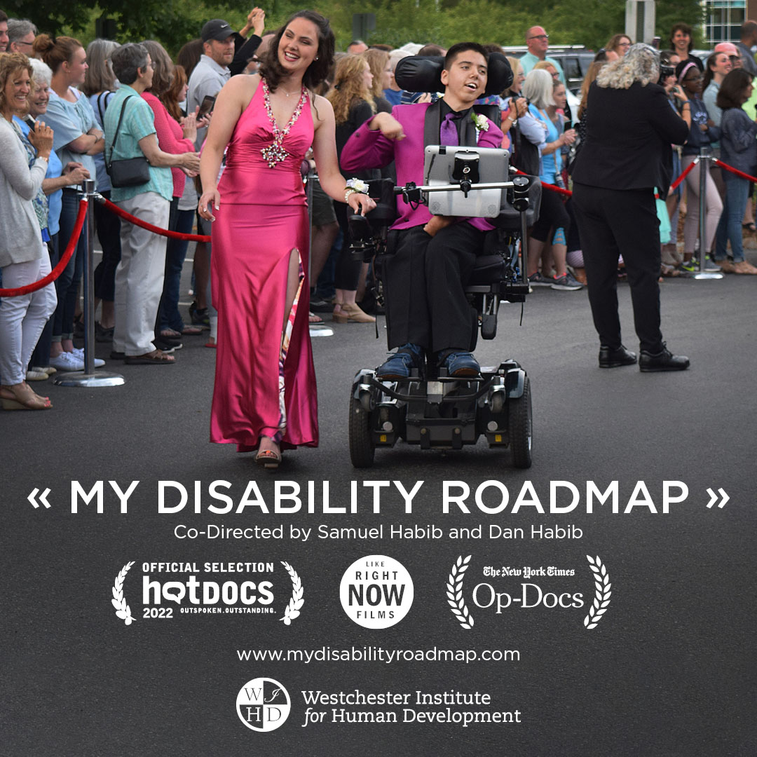 Image of Samuel a young white man dressed in a tuexedo using a powered wheelchair and a young woman wearing a promo dress smiling at the camera.