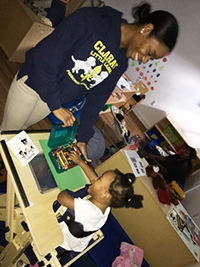 Diverse by Design: Integrating Early Childhood Programs, Keenya Finley at the Early Learning Center and child playing with crayons and Mickey Mouse card