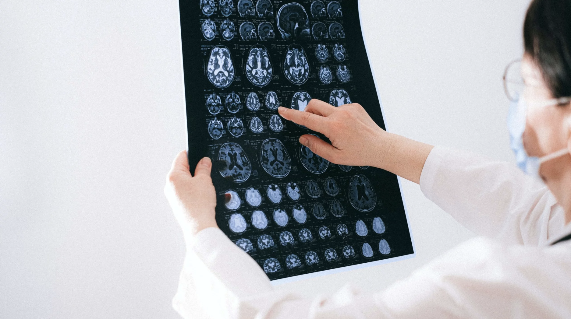 Person looks at scans of someone's brain on a screen. 