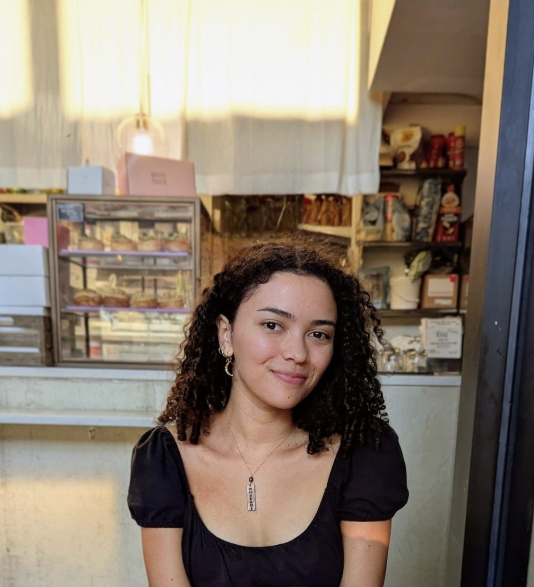 Photo of woman with brown curly hair and black shirt