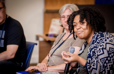 Woman with twists holding a microphone,