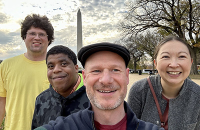 Four Network members are standing in front of the Washington Monument.