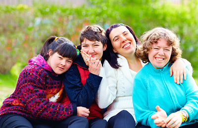 A family sitting together and smiling at the camera.