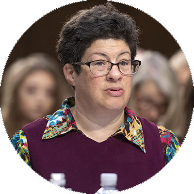 Image of Liz Weintraub, a white woman with short, black hair and glasses. Liz sits in a court room advocating.