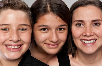 Image of a young child and woman smiling at the camera.