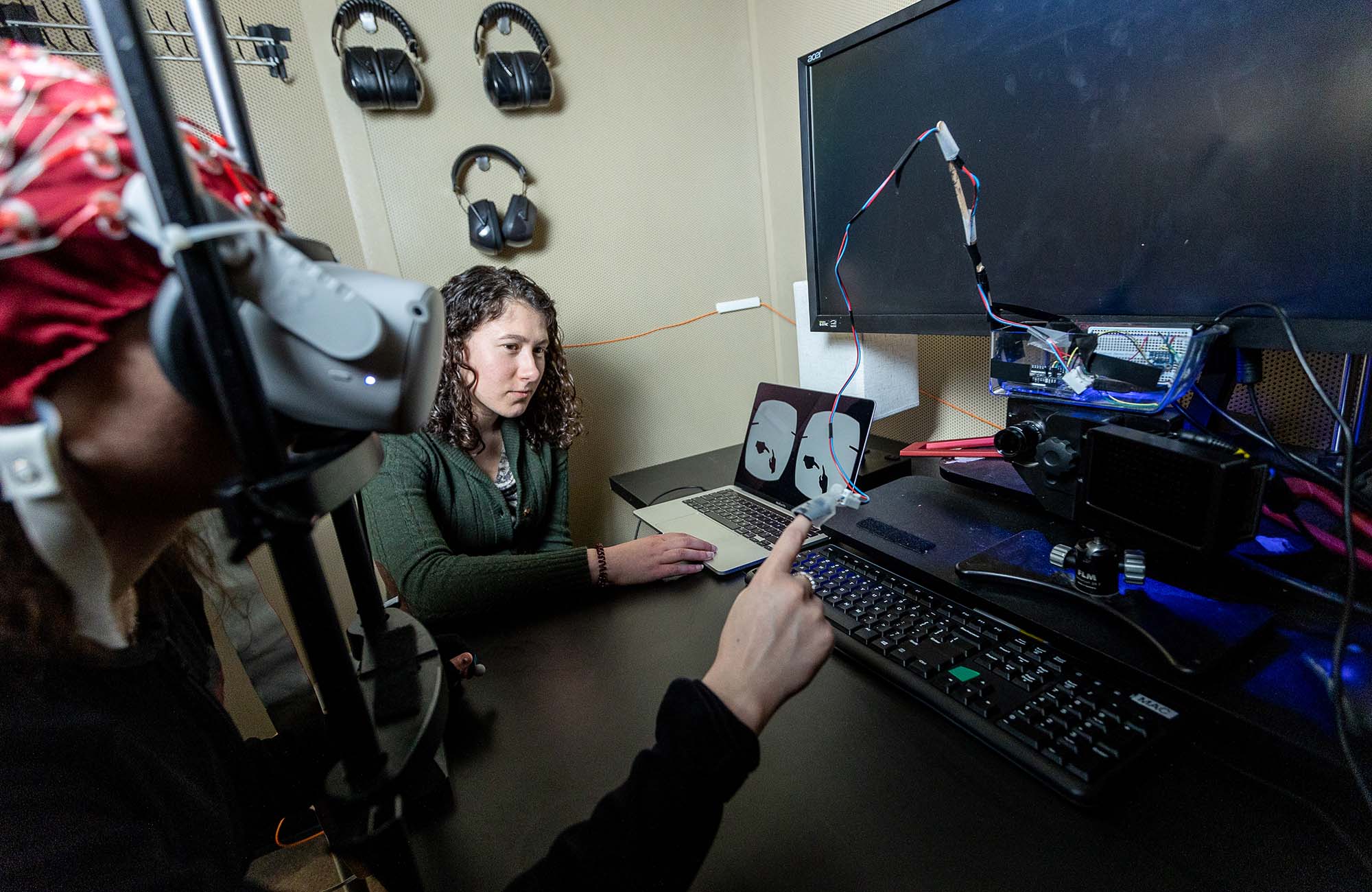 Isenstein (right) in 2024, with a subject in an EEG booth in the Frederick J. and Marion A. Schindler Cognitive Neurophysiology Lab at the University of Rochester Medical Center. Isenstein uses the advancements she developed to better understand how the brain responds to active and passive touch.