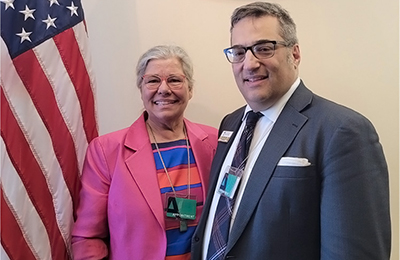 Kim Moody (executive director of Disability Rights Maine) and Alan Cobo-Lewis (ME UCEDD) Alt text: Two people, a woman and a man, standing in the White House complex next to an indoor American flag, with the White House shield above their heads.