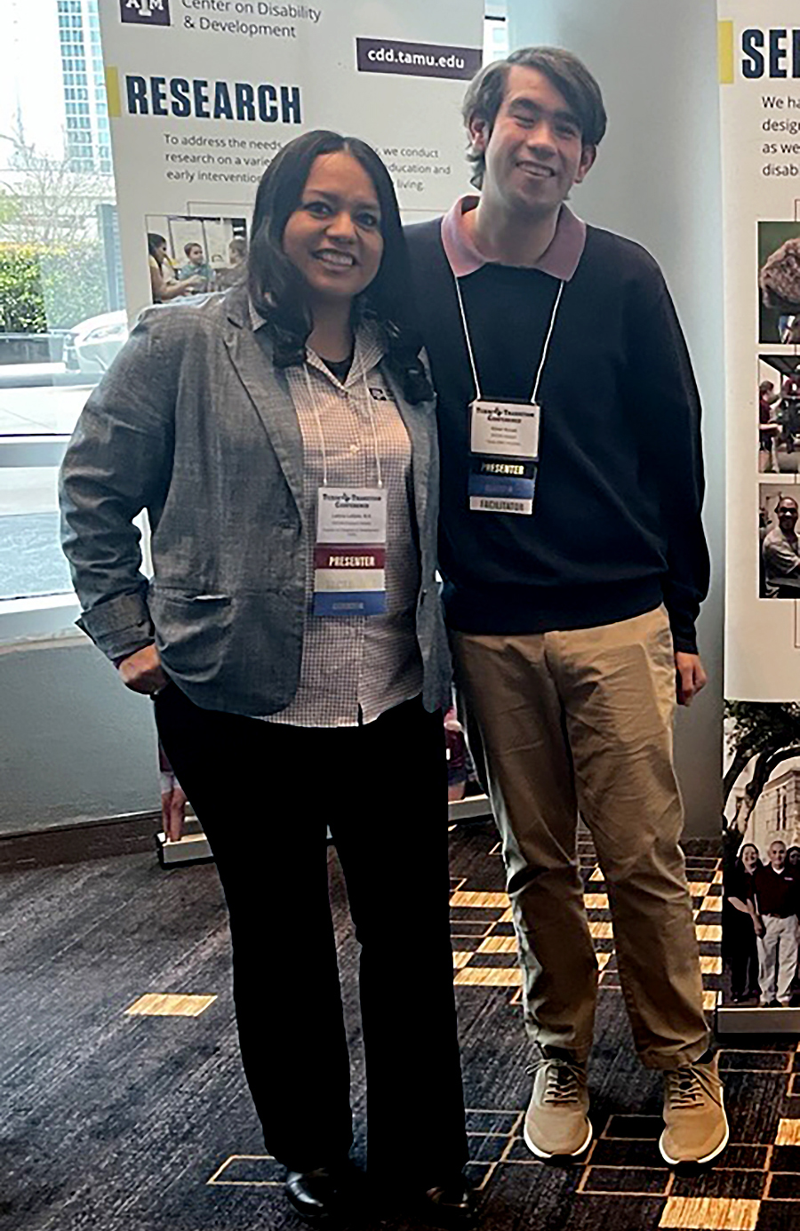 Image of TAMU Staff wearing professional attire standing in front of a Academic Poster