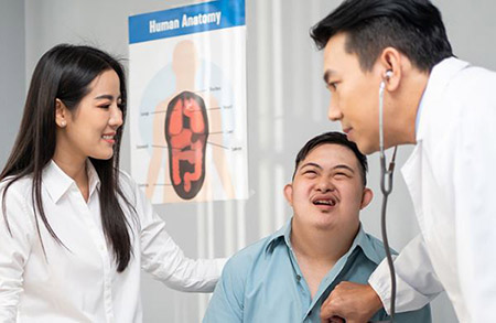  A doctor checking heartbeat of person with a disability with a caregiver looking on. 