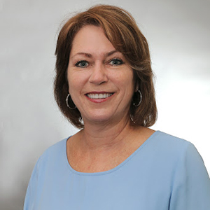 Linda Russo, a white woman with shoulder length hair wearing a blue blouse.