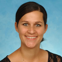 Image of Amy Burt, a woam with pulled back brown hair and she is wearing a blouse.