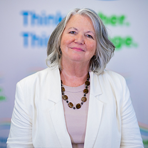 Image of John Butterworth, a white man with short grey hair wearing glasses, he is wearing a shirt and vest.
