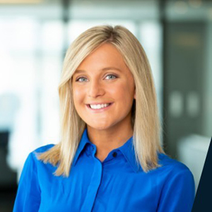 Image of Brad Thomas, a white man smiling wearing a red and white checked polo-button-up shirt.
